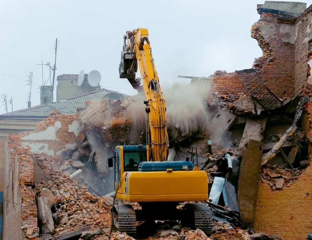 Yellow excavator demolishing a brick building on the Gold Coast