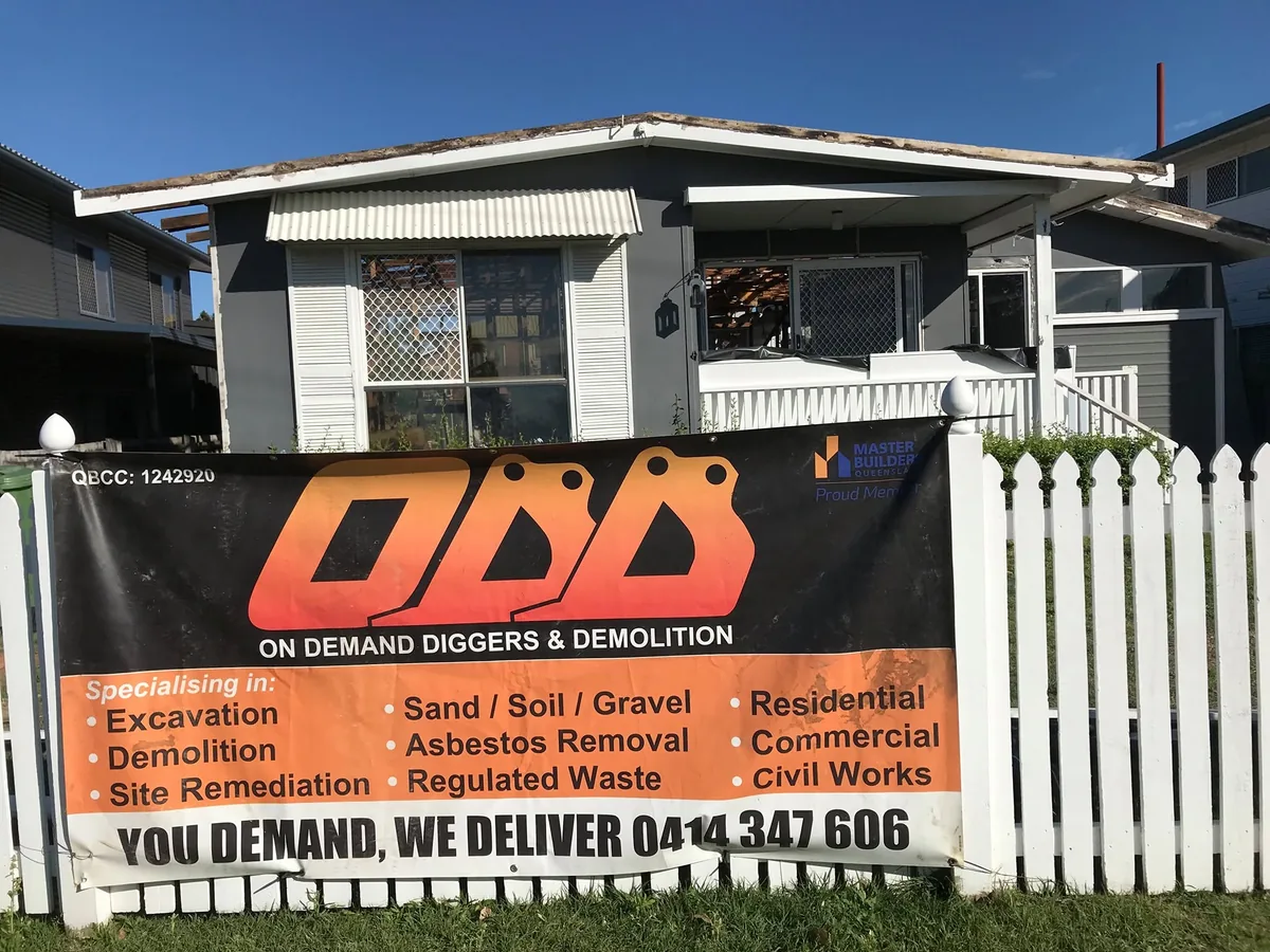 House with roof covering removed behind an On Demand Diggers & Demolitions banner.