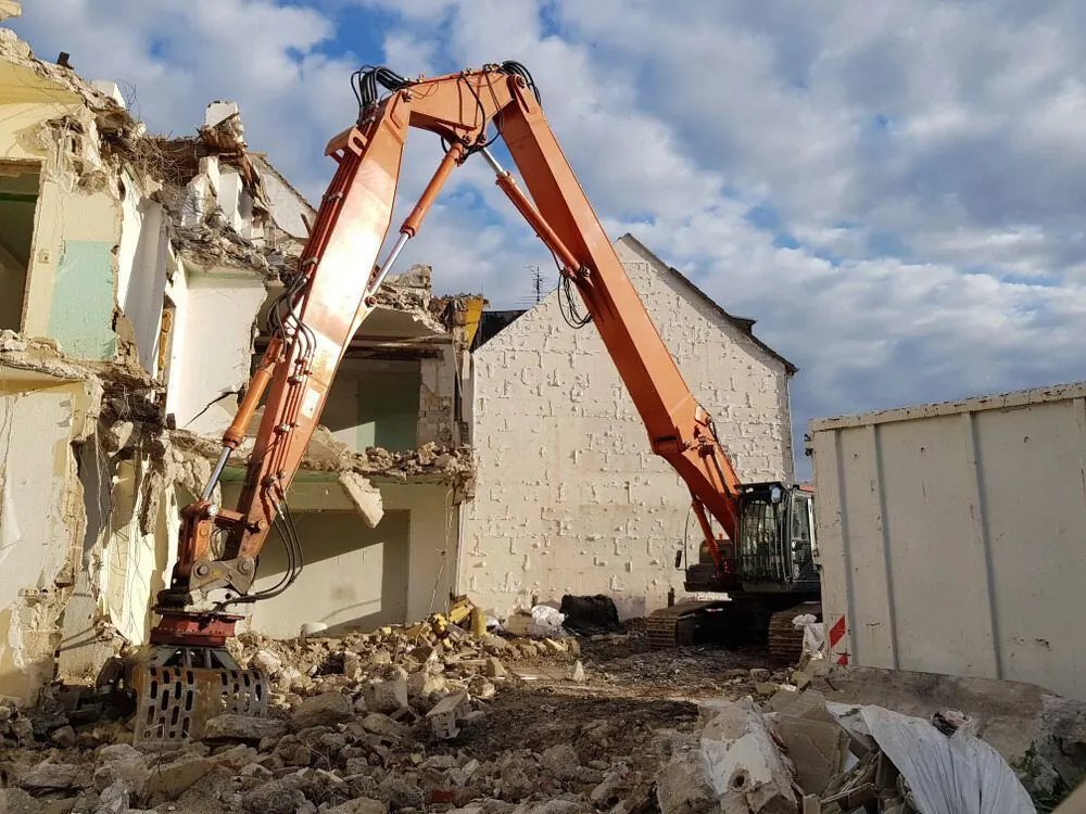 High-reach excavator demolishing a multi-storey building on a Gold Coast demolition site